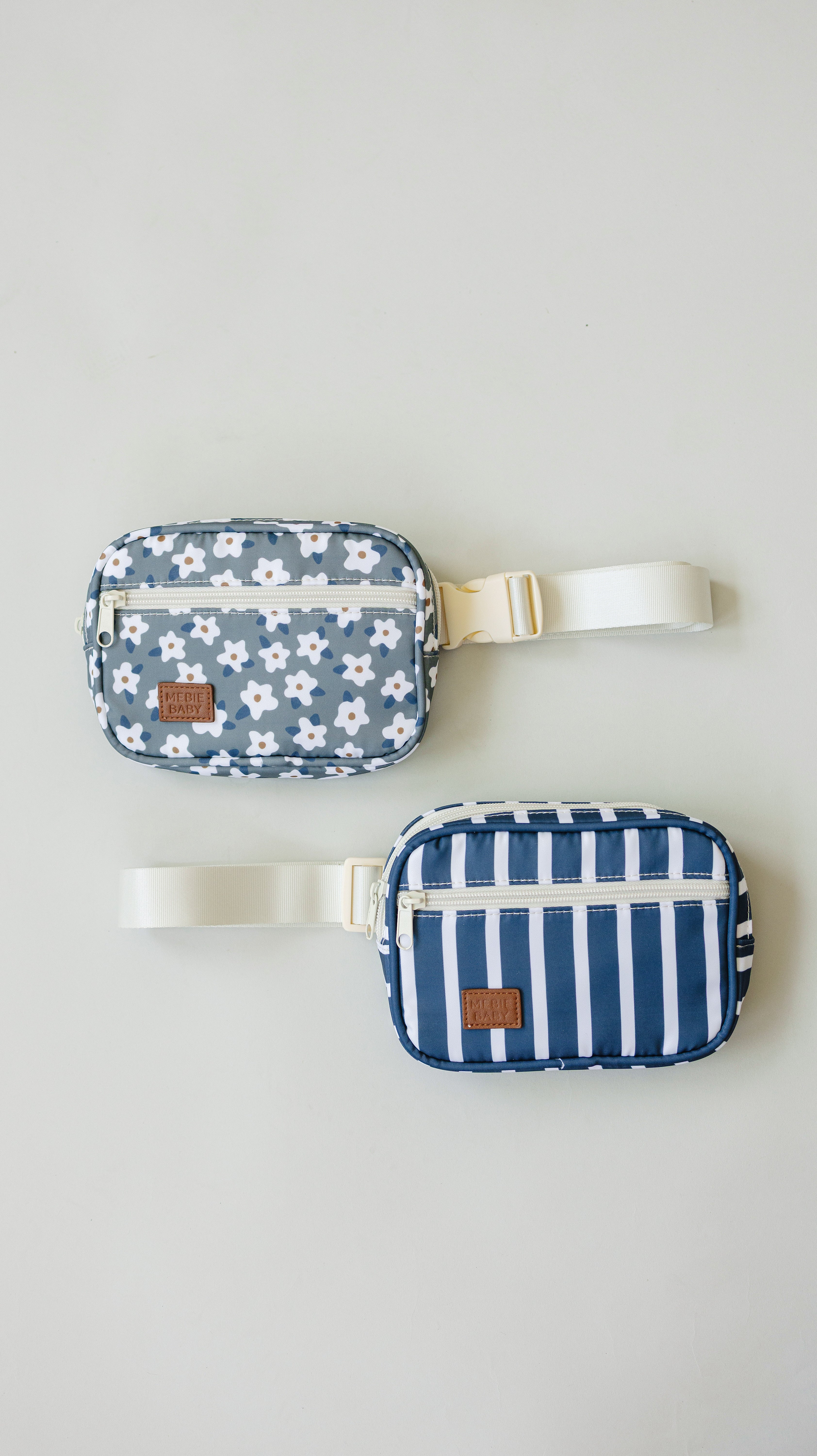 Two mini fanny packs in floral and striped designs, perfect for kids, showcasing playful patterns and adjustable straps.