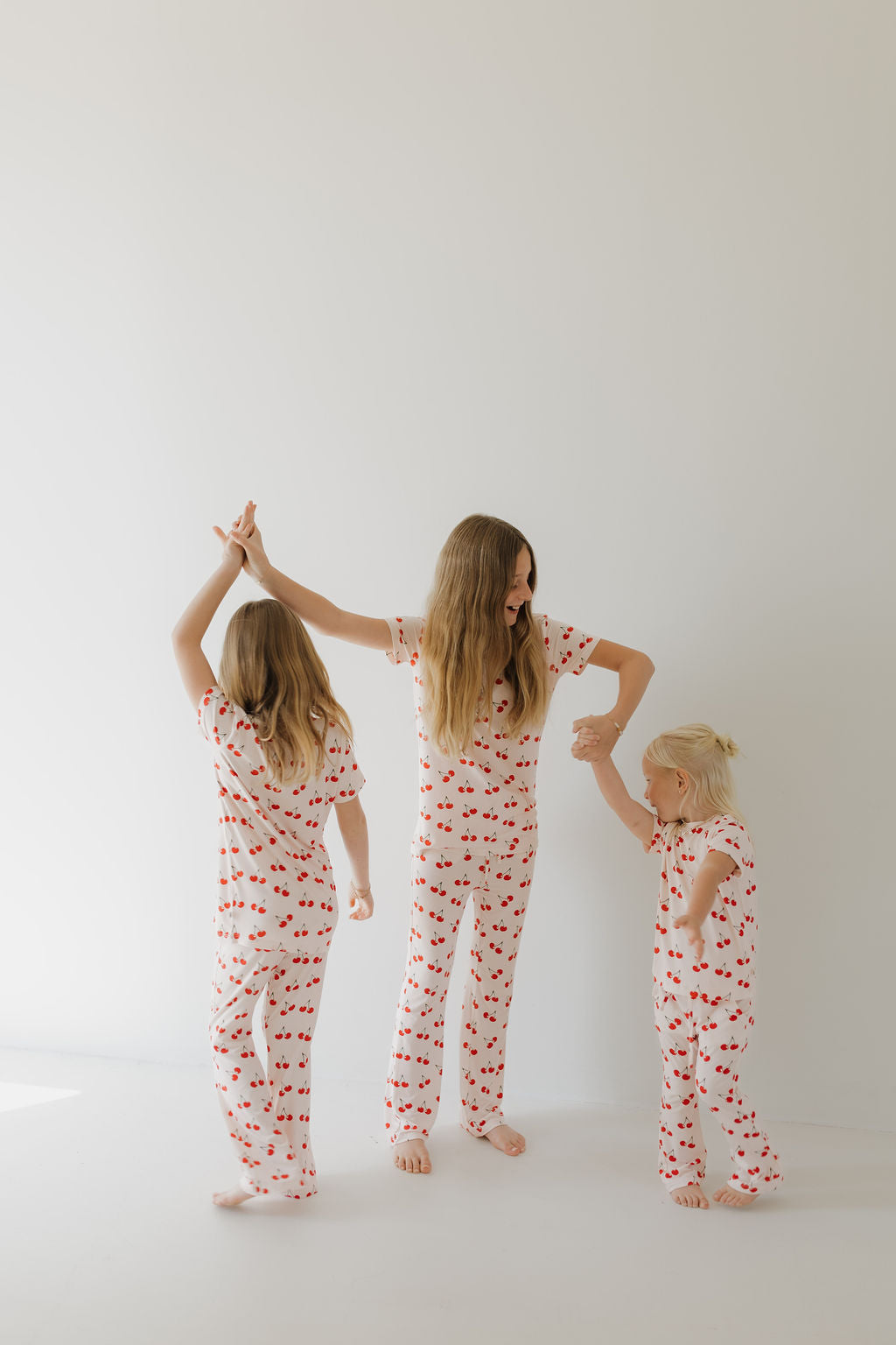 Three children wearing Cherry Orchard bamboo lounge sets, playing and having fun in soft, cozy pajamas.