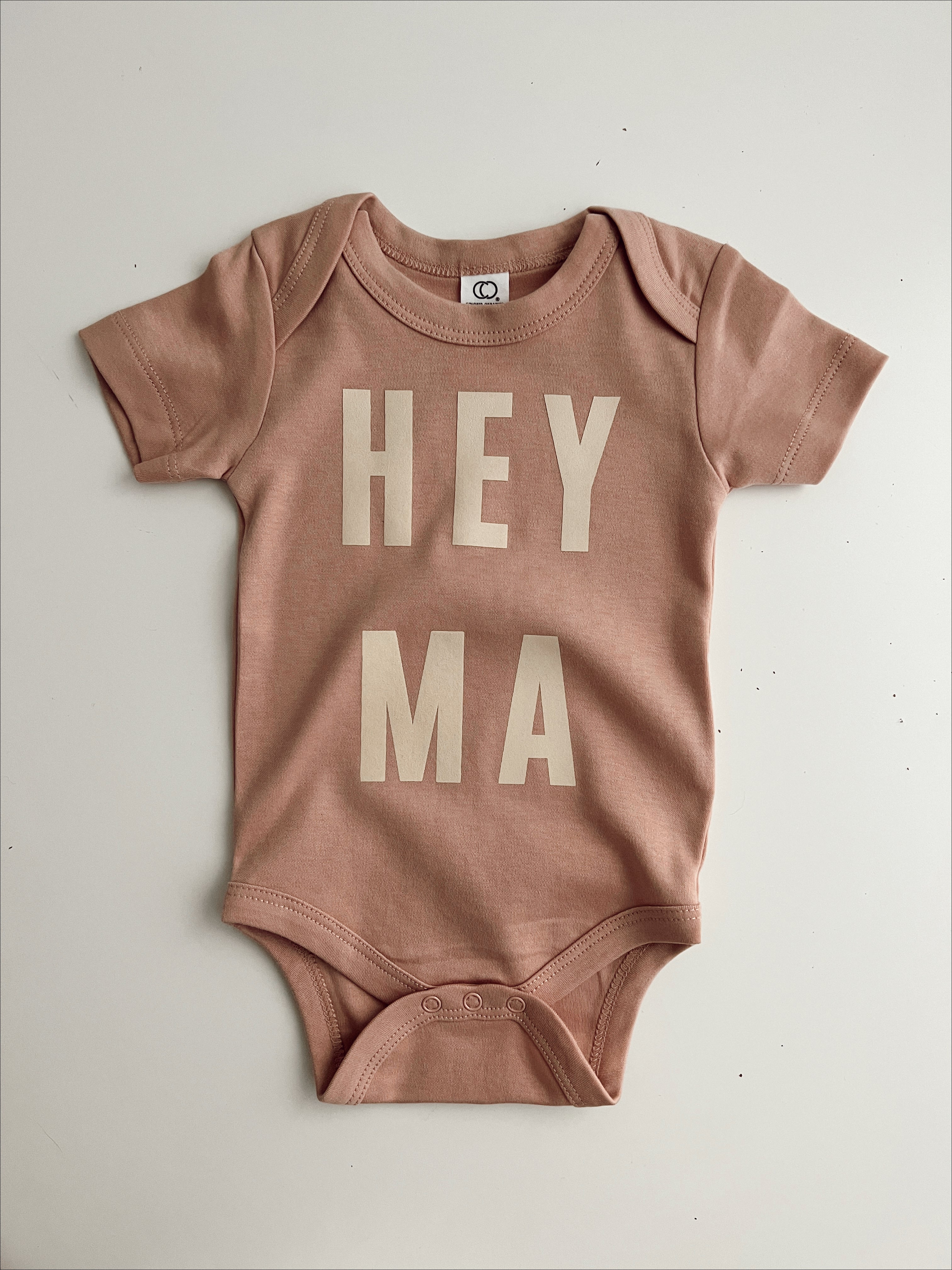 Hey Ma organic baby onesie in soft pink with playful letters, perfect for trendy and cool baby outfits.